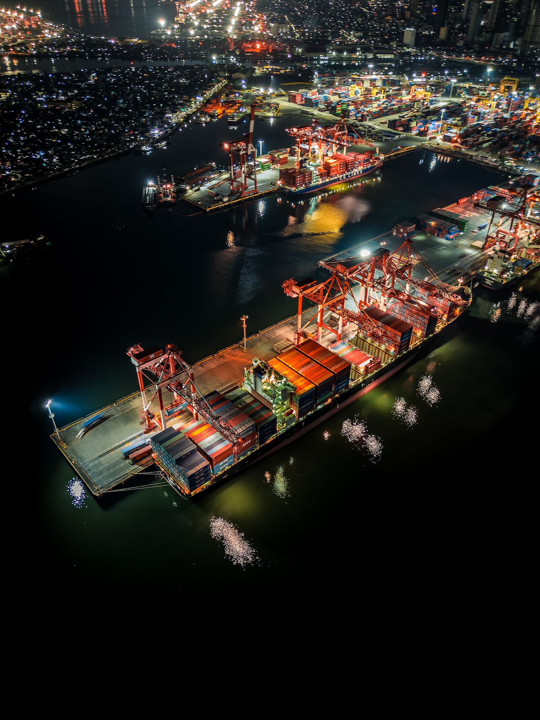 Beleuchteter Containerhafen bei Nacht, internationale Logistik